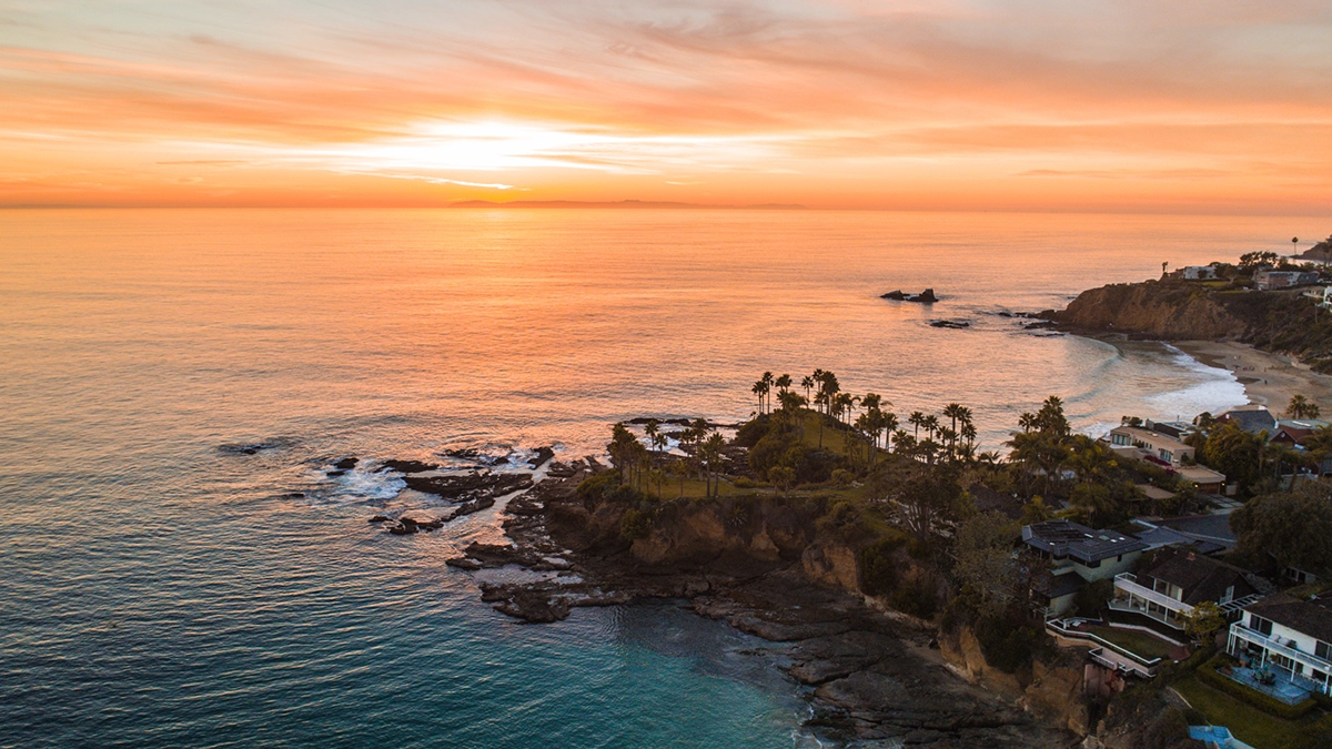 Bright orange sunset along the Orange County, California coastline overlooking the Pacific Ocean.